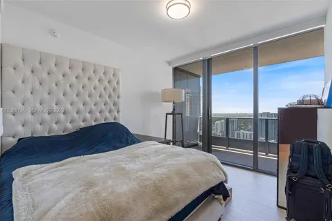 a bedroom with a large bed and wooden floor