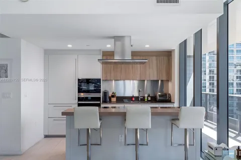 a kitchen with a table chairs refrigerator and cabinets