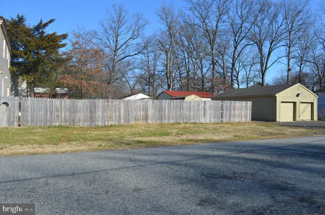 a view of a yard with swimming pool and wooden fence