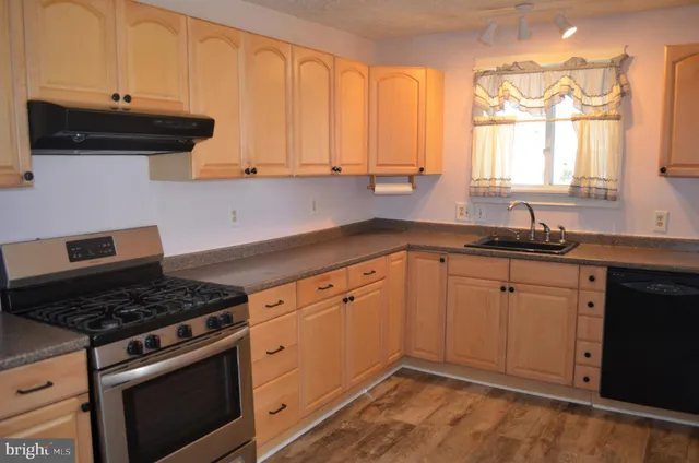 a kitchen with granite countertop a stove and a sink