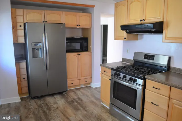 a kitchen with stainless steel appliances wooden cabinets and a stove