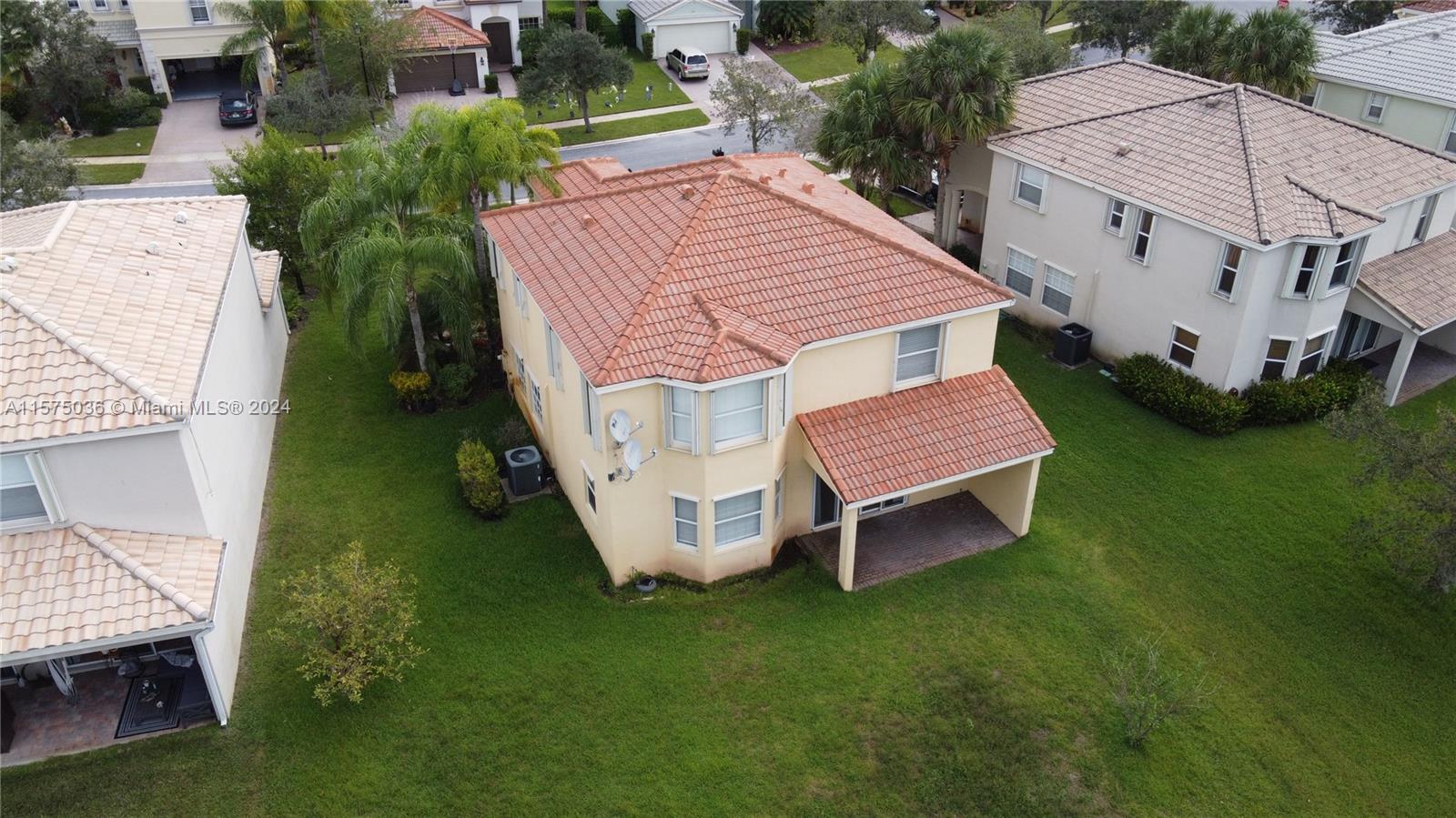 aerial view of a house with a yard and sitting area