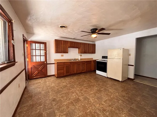 a view of kitchen with furniture and a ceiling fan