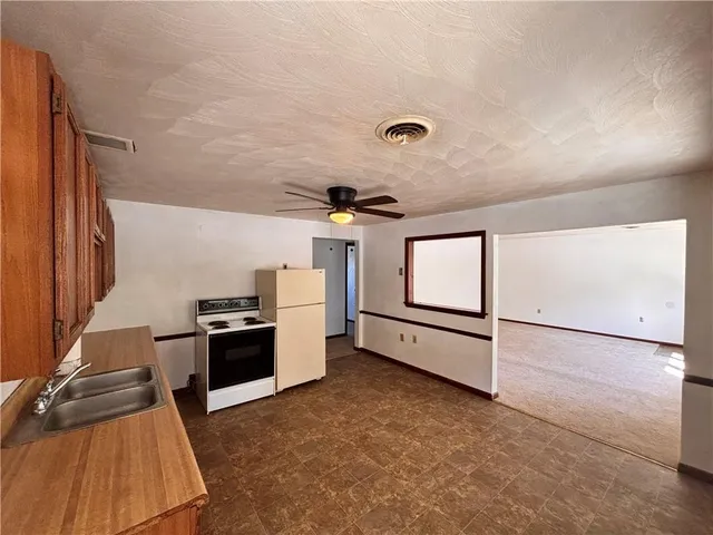 a kitchen with granite countertop a stove a sink and a refrigerator