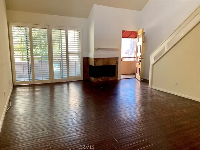 a view of a livingroom with wooden floor and a fireplace