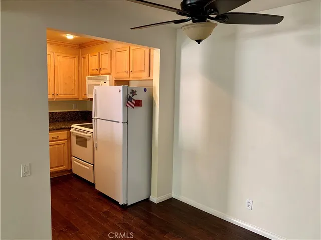 a view of a kitchen with wooden floor and a refrigerator