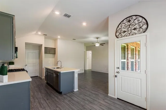 a view of an empty room with wooden floor and windows
