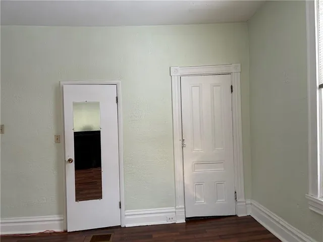 an empty room with wooden floor and closet