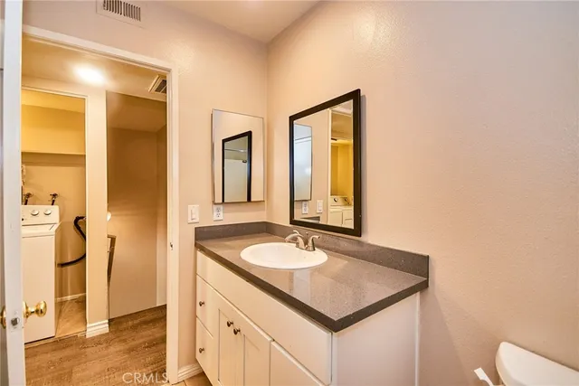 a bathroom with a granite countertop sink and a mirror