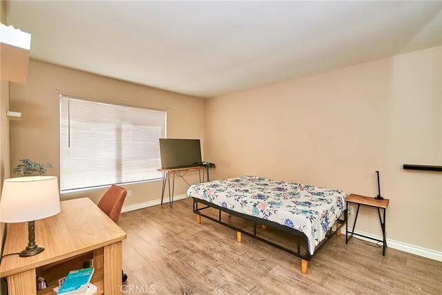 a bedroom with a bed and wooden floor