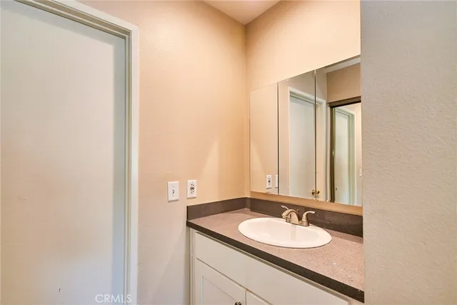 a bathroom with a granite countertop sink and a mirror