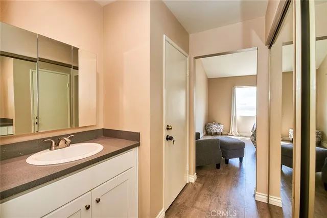 a en suite bathroom with a granite countertop sink and a mirror