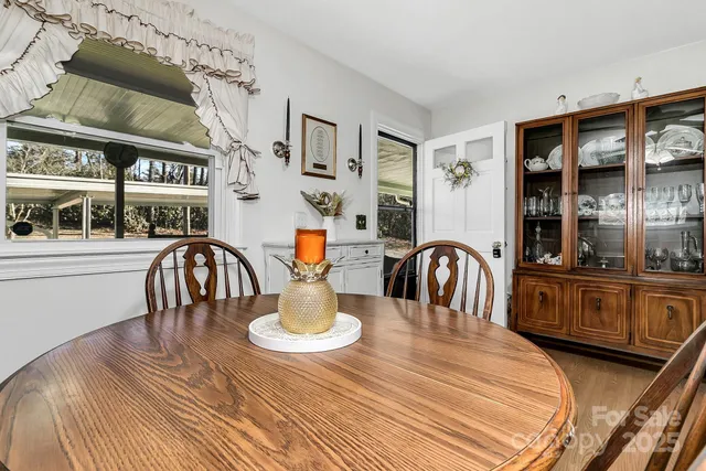 a dining room with wooden floor a chandelier a wooden table and chairs