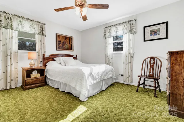 a bedroom with a bed chair and wall painting