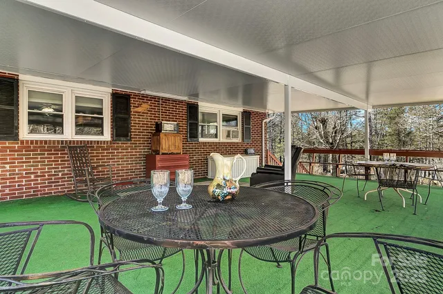 a patio with table and chairs and potted plants