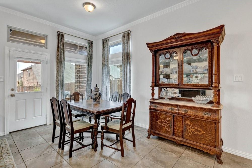 4105 Ranchman Boulevard Denton, TX 76210 - Photo 11 of 39 a dining room with a wooden table and chairs