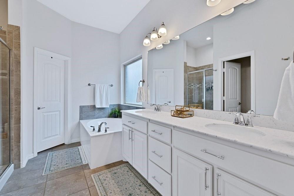 4105 Ranchman Boulevard Denton, TX 76210 - Photo 17 of 39 a spacious en suite bathroom with a double sink double vanity and mirror
