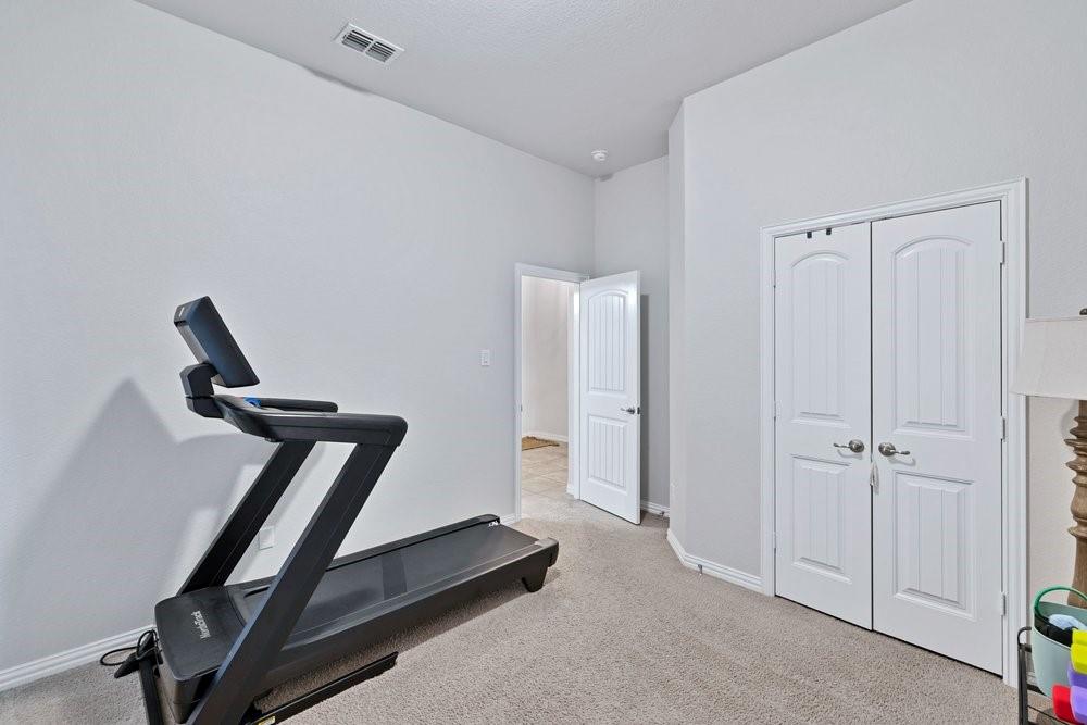 4105 Ranchman Boulevard Denton, TX 76210 - Photo 25 of 39 a room with gym equipment and a ceiling fan