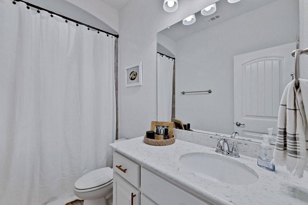 4105 Ranchman Boulevard Denton, TX 76210 - Photo 29 of 39 a bathroom with a granite countertop sink toilet and shower