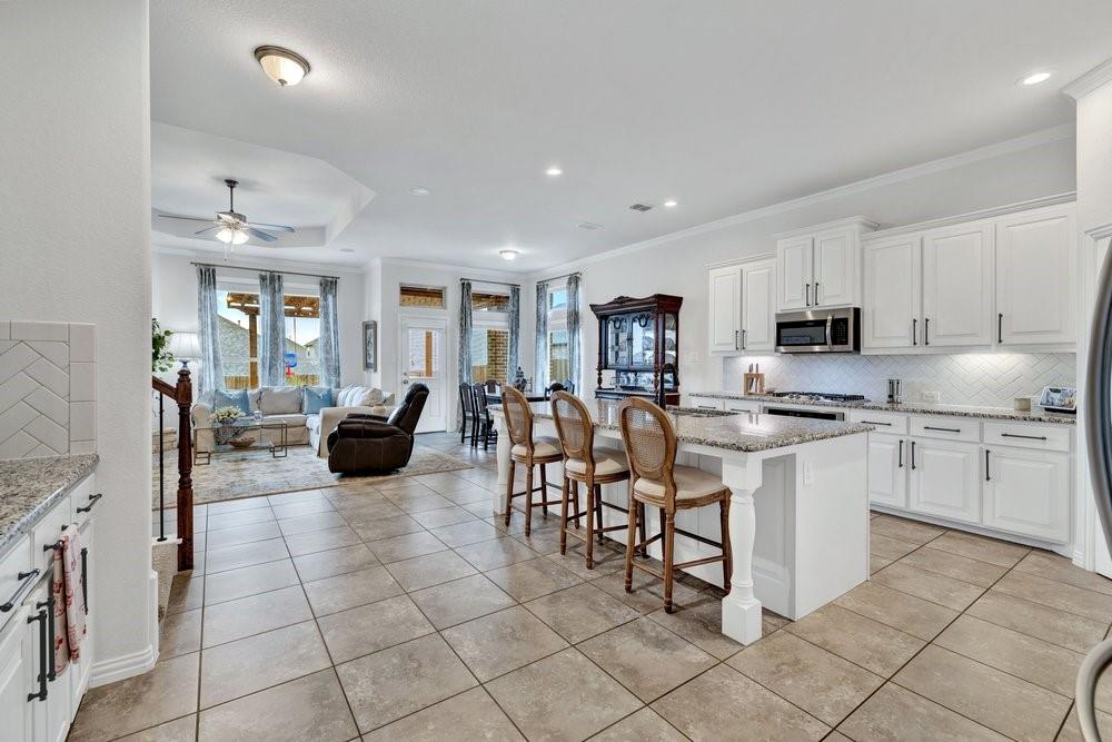 4105 Ranchman Boulevard Denton, TX 76210 - Photo 5 of 39 a kitchen with stainless steel appliances granite countertop a stove and a sink
