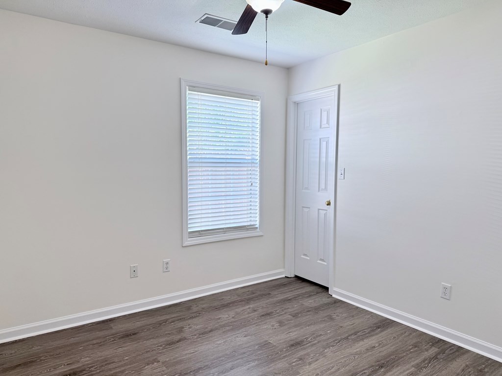 497 Sivley Road Hopkinsville, KY 42240 - Photo 13 of 20 an empty room with wooden floor chandelier fan and windows