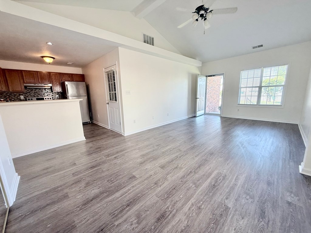 497 Sivley Road Hopkinsville, KY 42240 - Photo 8 of 20 a view of an empty room with wooden floor and a kitchen