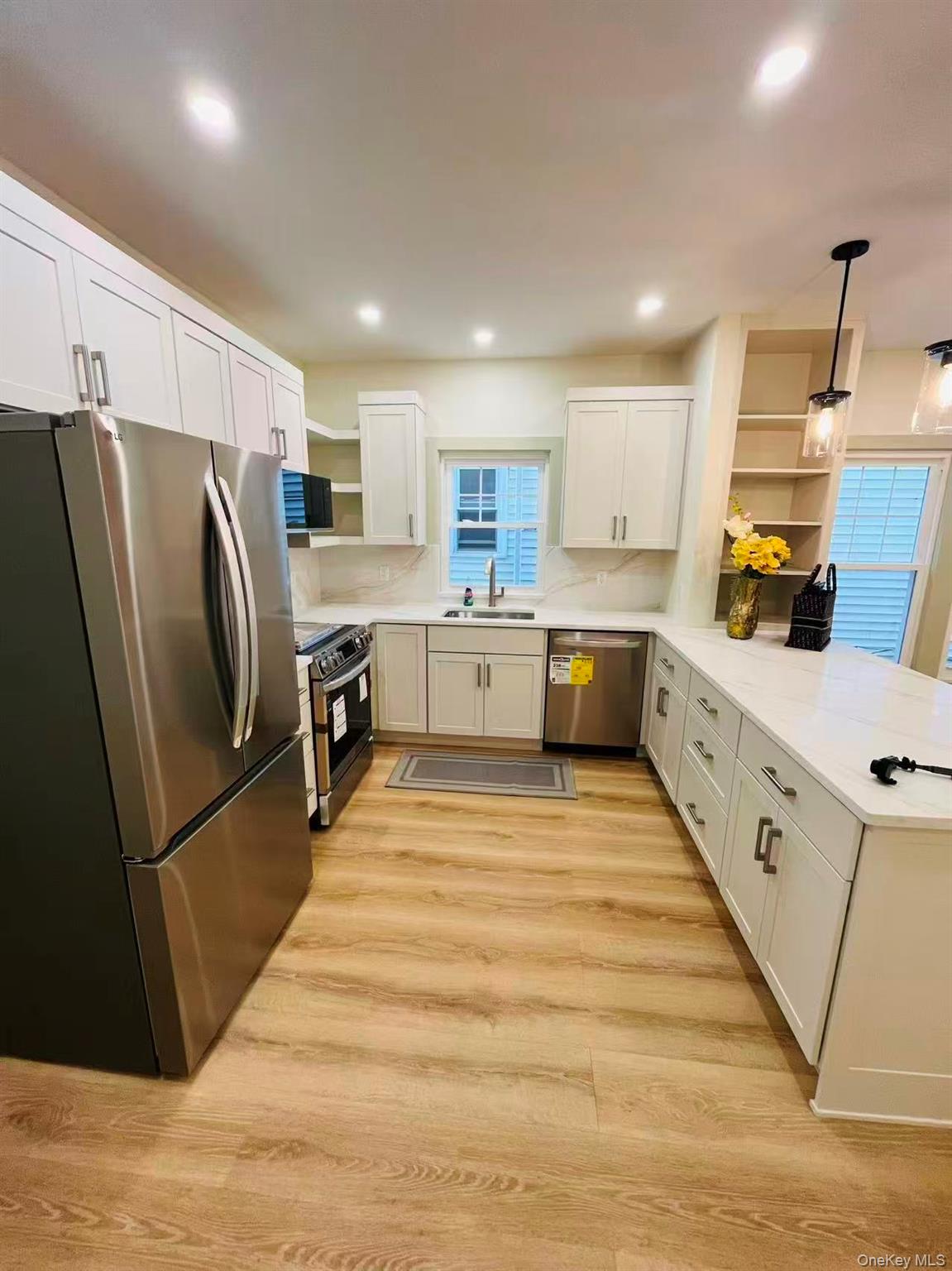 84-33 124th Street Queens, NY 11415 - Photo 11 of 27 a large kitchen with stainless steel appliances kitchen island granite countertop a refrigerator and a stove top oven