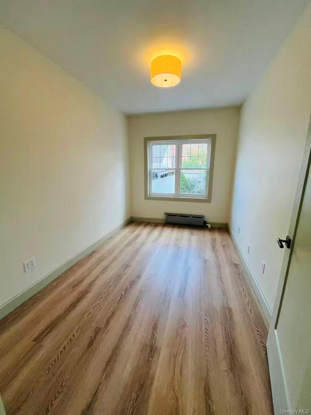 84-33 124th Street Queens, NY 11415 - Photo 13 of 27 a view of empty room with a window and wooden floor