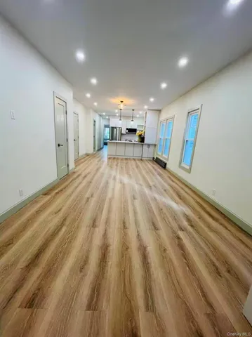 a kitchen with stainless steel appliances a refrigerator a stove a sink dishwasher and white cabinets with wooden floor