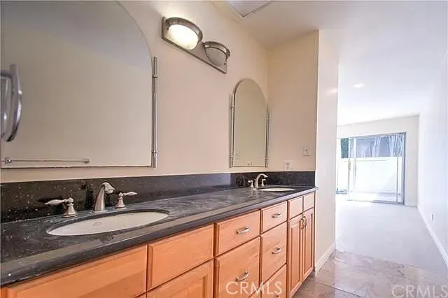 a bathroom with double sink and a mirror