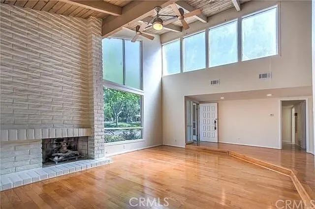 a view of an empty room with a fireplace and a window