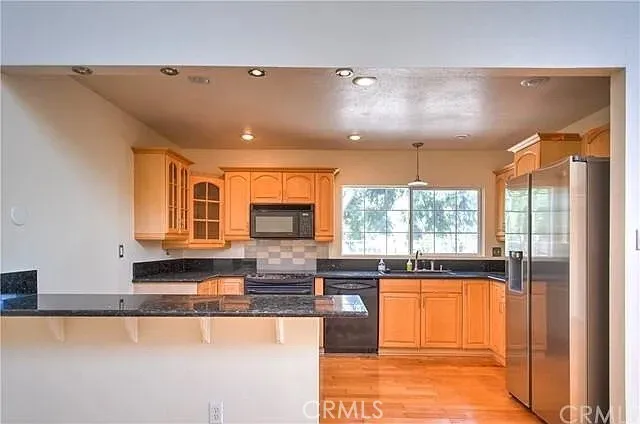 a kitchen with stainless steel appliances granite countertop a stove a sink and a microwave