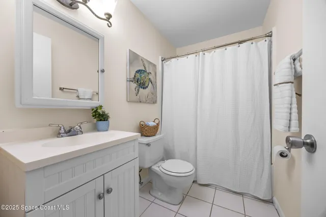 a bathroom with a sink a toilet and shower curtain
