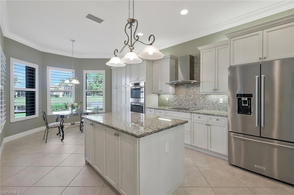 3384 Atlantic Circle Naples, FL 34119 - Photo 12 of 50 a kitchen with stainless steel appliances granite countertop a refrigerator a sink a stove and white cabinets