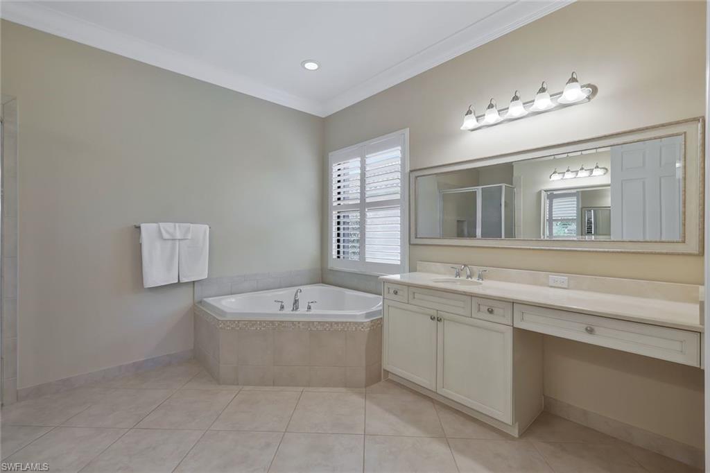 3384 Atlantic Circle Naples, FL 34119 - Photo 22 of 50 a spacious bathroom with a bathtub a sink and a mirror