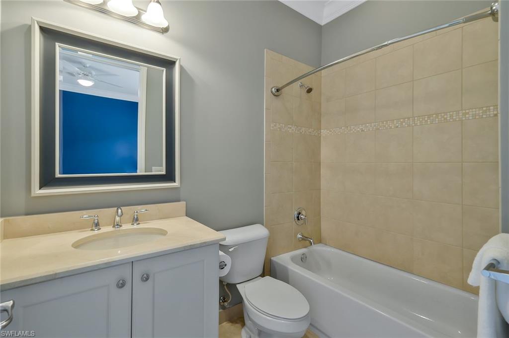 3384 Atlantic Circle Naples, FL 34119 - Photo 29 of 50 a bathroom with a granite countertop sink a toilet and shower