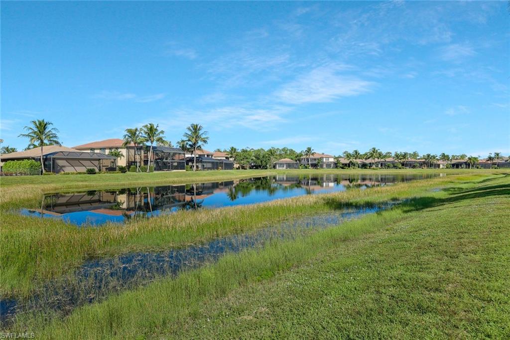 3384 Atlantic Circle Naples, FL 34119 - Photo 35 of 50 a view of a lake with houses in the background
