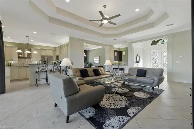 a living room with furniture kitchen view and a chandelier