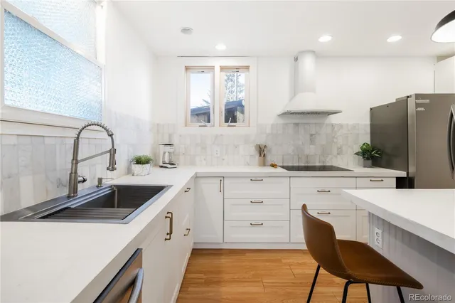 a kitchen with a sink a stove a refrigerator and cabinets