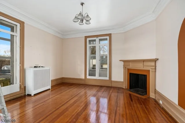 wooden floor fireplace and windows in an empty room