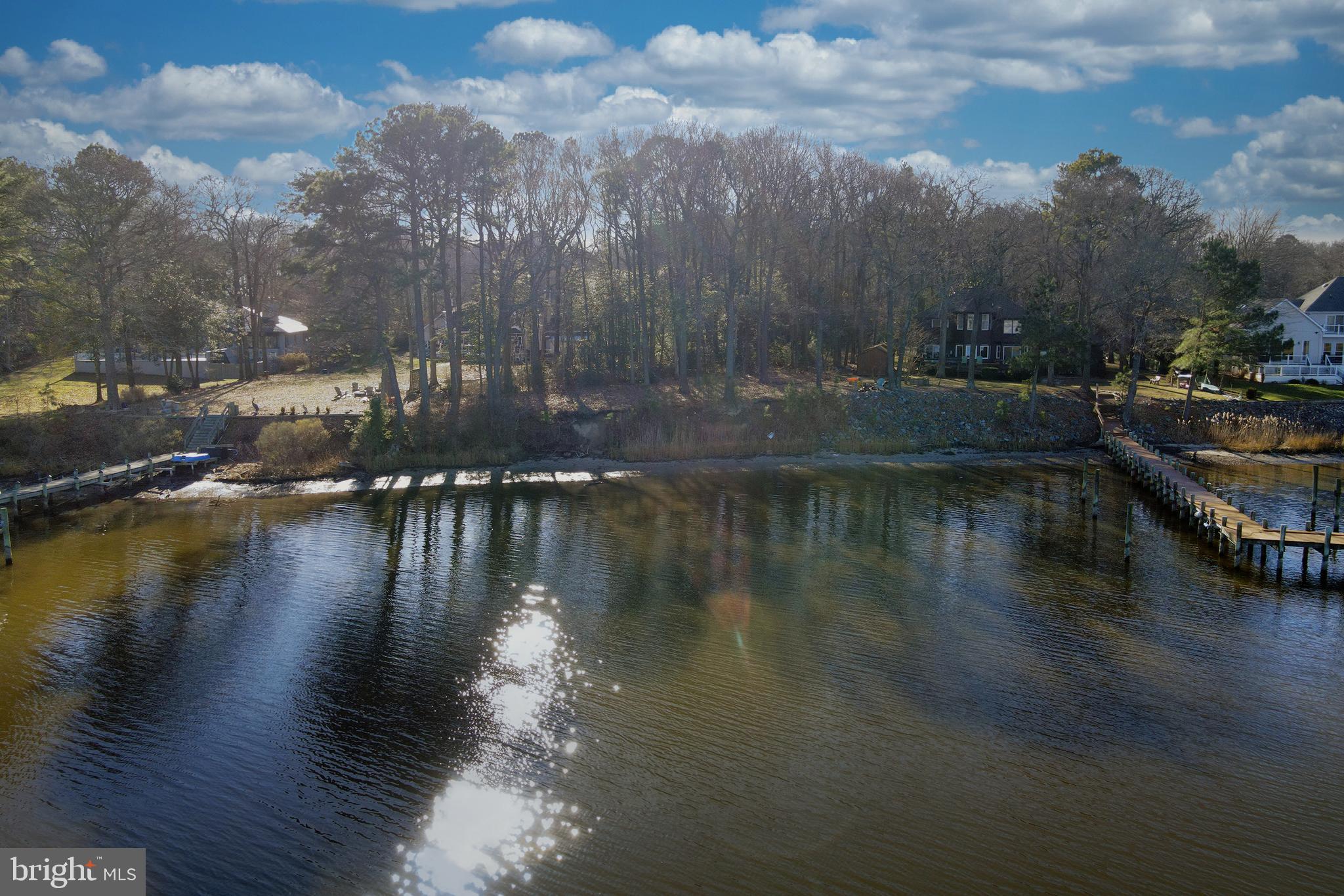 0 South Piney Point Road Bishopville, MD 21813 - Photo 5 of 7 a view of a lake with boats and trees in the background