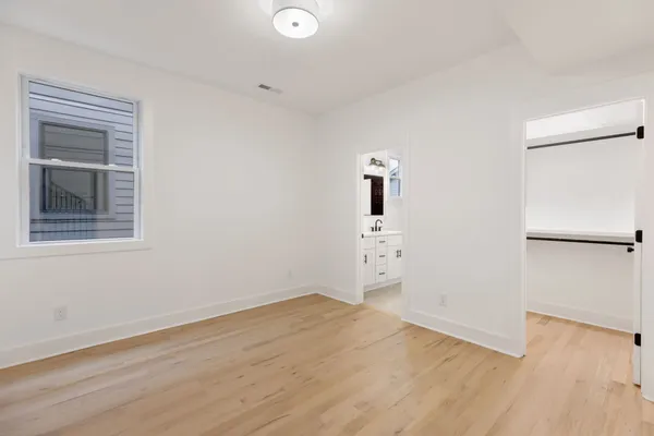 an empty room with wooden floor and window
