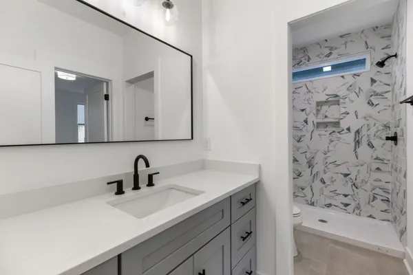 a bathroom with a bathtub sink vanity and mirror