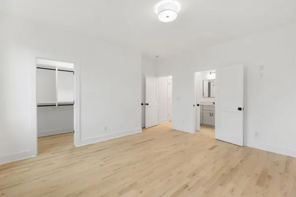 a view of a big room with wooden floor and windows