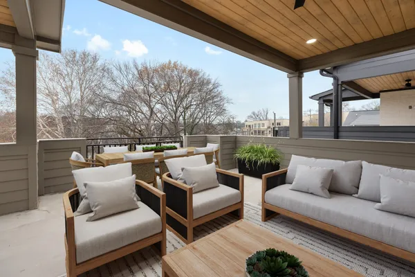 a roof deck with couches and wooden floor