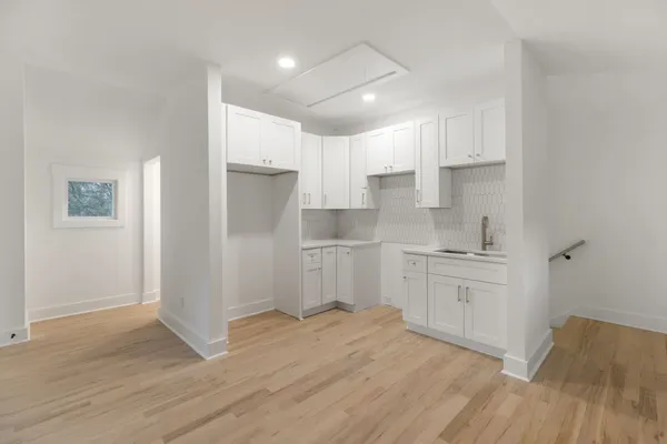 a kitchen with granite countertop white cabinets and white appliances