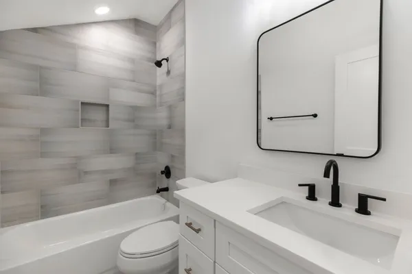 a bathroom with a granite countertop sink toilet and shower
