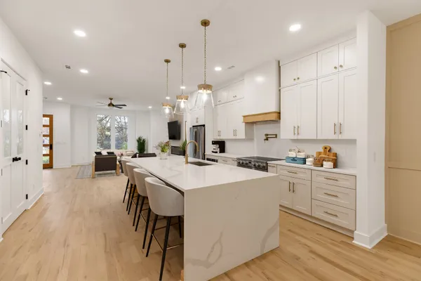 a large kitchen with kitchen island a island a sink a stove and a center island
