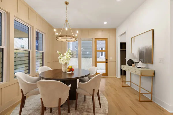 a dining room with furniture a chandelier and wooden floor
