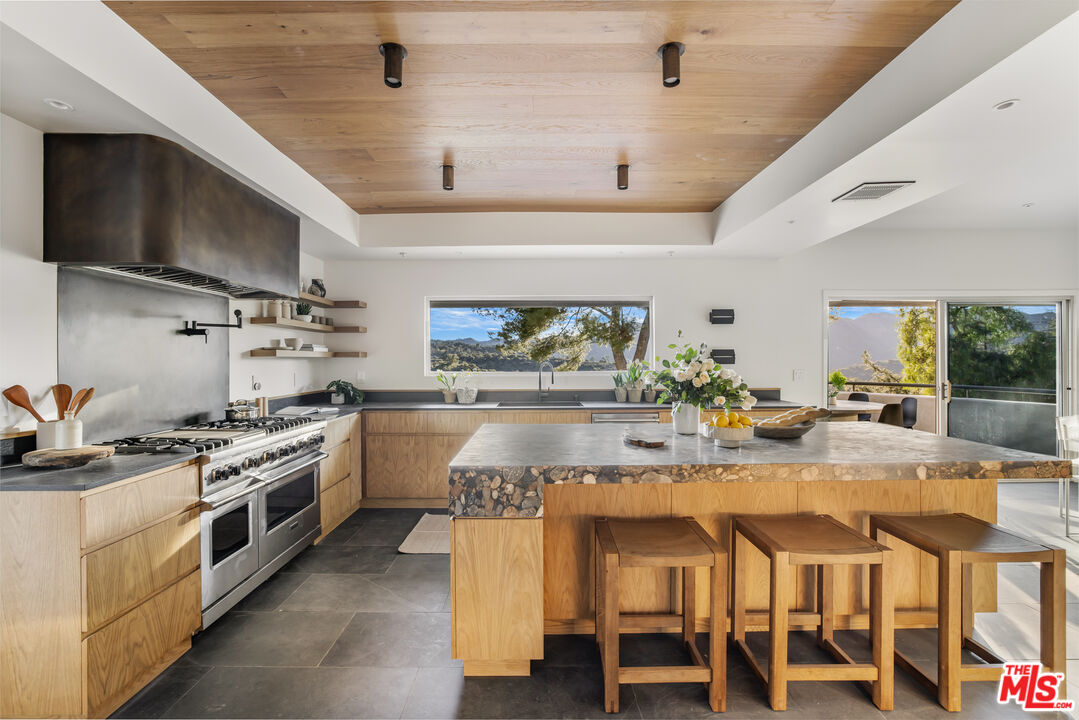 20711 Hillside Drive Topanga, CA 90290 - Photo 13 of 41 a kitchen with stainless steel appliances granite countertop a stove and a refrigerator